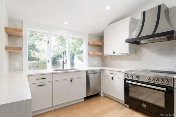 a kitchen with a stove a sink and a window
