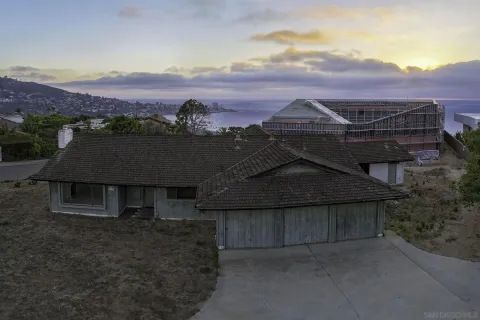 an aerial view of house with yard and mountain view in back