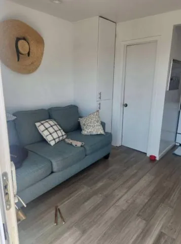 a view of a bedroom with wooden floor and lounge chair