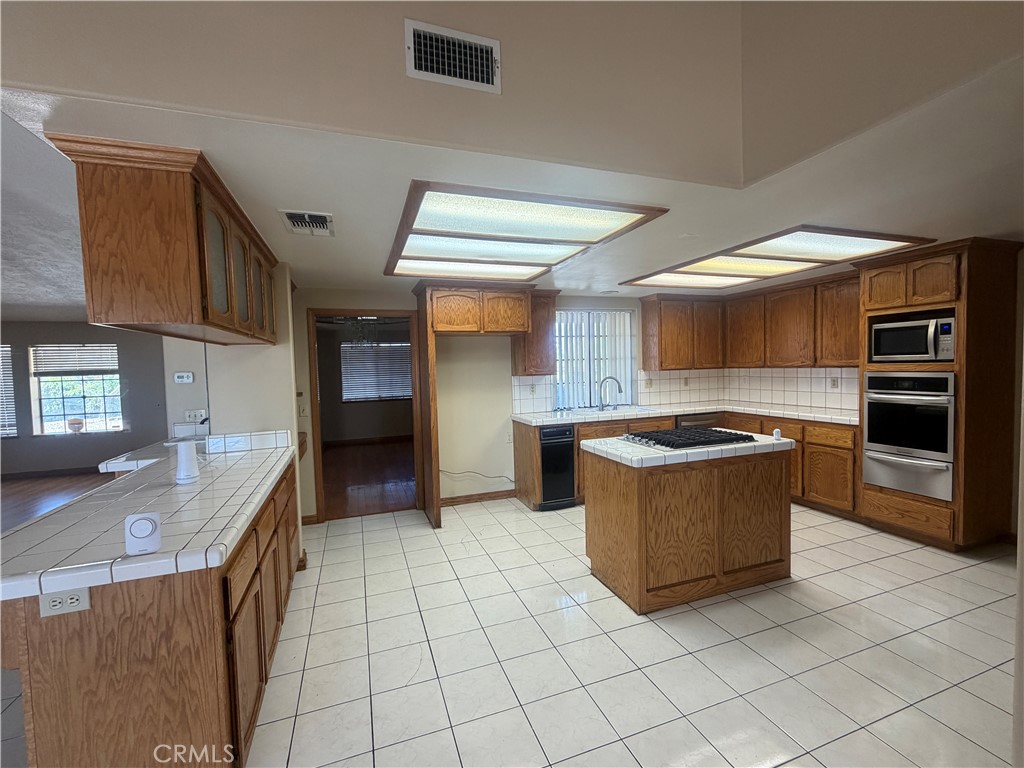 19609 Seneca Road Apple Valley, CA 92307 - Photo 11 of 37 a kitchen with stainless steel appliances granite countertop a stove and a sink