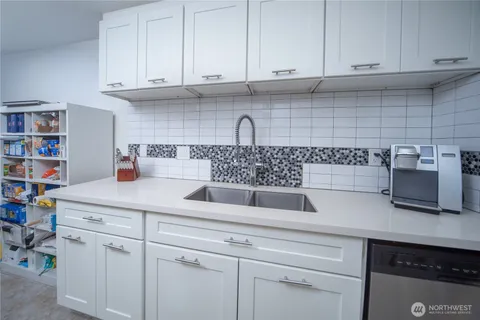 a kitchen with white cabinets and a sink