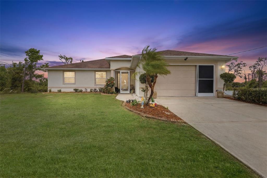 a front view of a house with a yard and garage