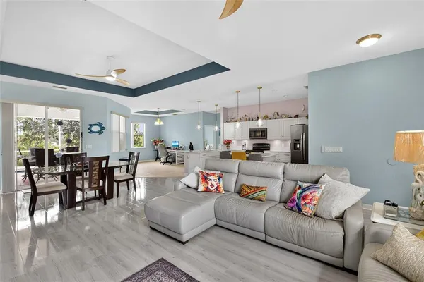 a living room with furniture and a dining table with wooden floor