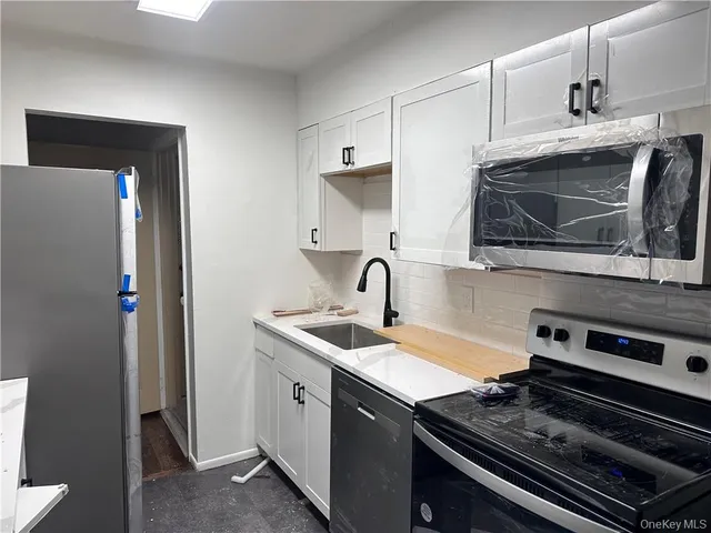 a kitchen with stainless steel appliances a sink stove and microwave