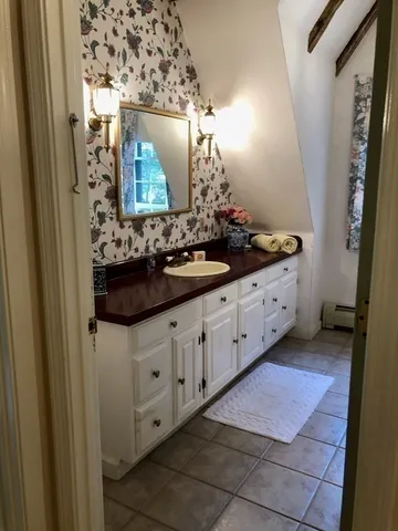 a bathroom with a granite countertop sink and a mirror