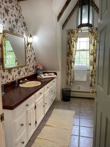 a kitchen with white cabinets and window