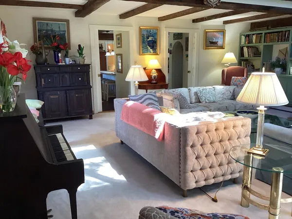 a bedroom with a large bed chandelier and a window