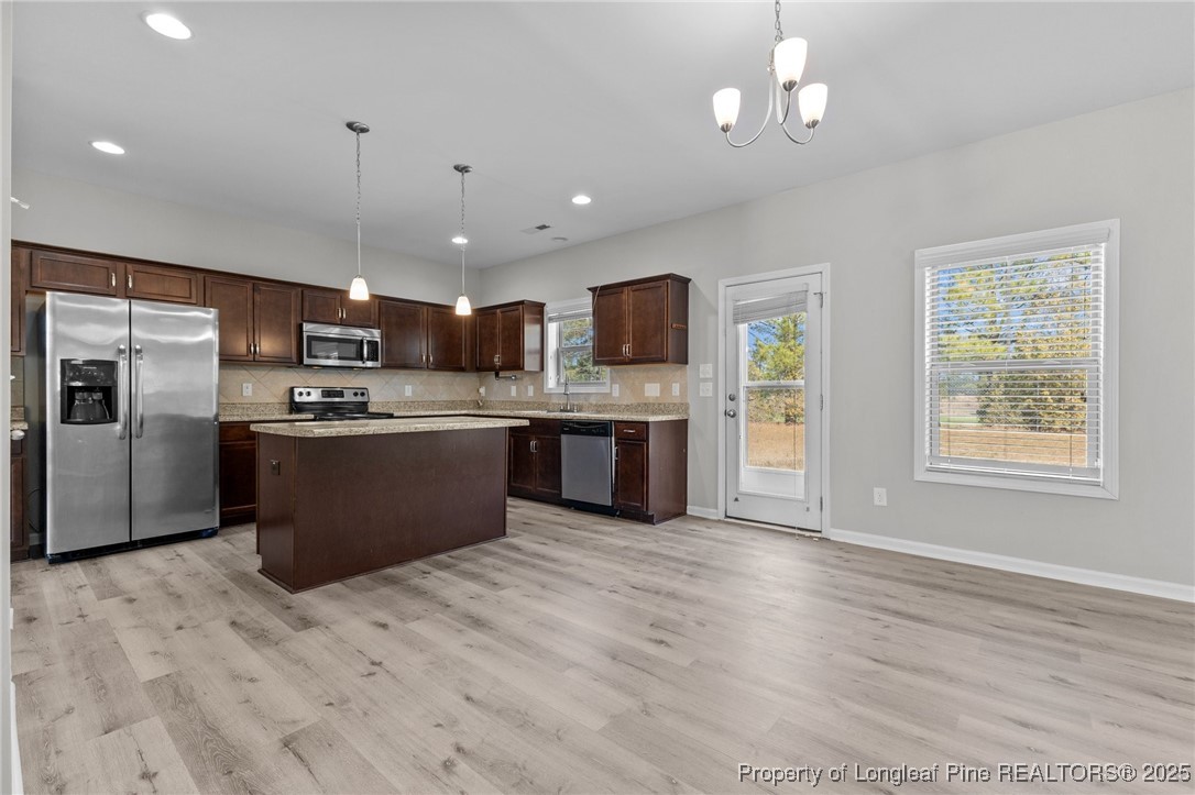 251 Crane Way Bunnlevel, NC 28323 - Photo 24 of 49 a kitchen with stainless steel appliances kitchen island granite countertop a refrigerator a stove top oven a sink dishwasher and white cabinets with wooden floor
