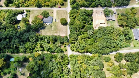 an aerial view of residential house with outdoor space and trees all around
