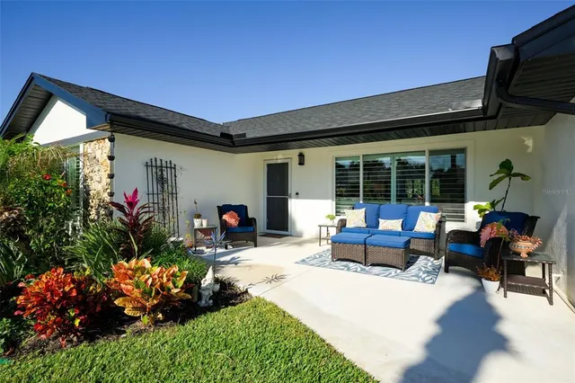 a view of a house with sitting area and garden