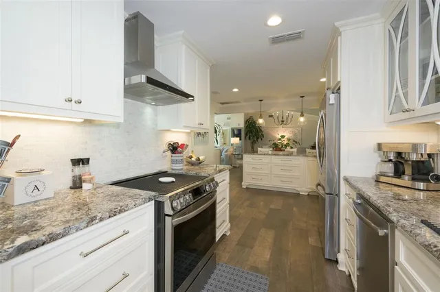 a kitchen with granite countertop a sink stove and cabinets