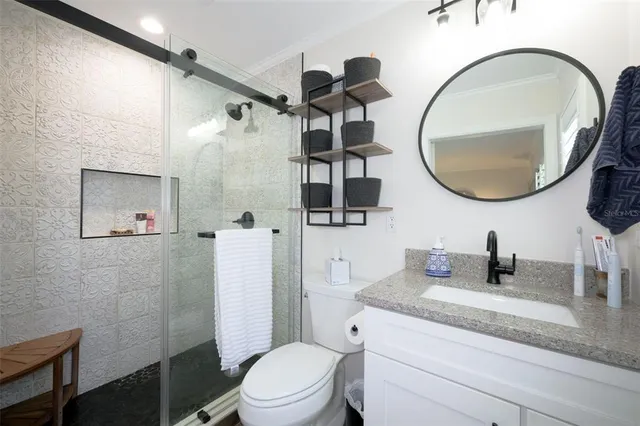 a bathroom with a granite countertop toilet sink and mirror
