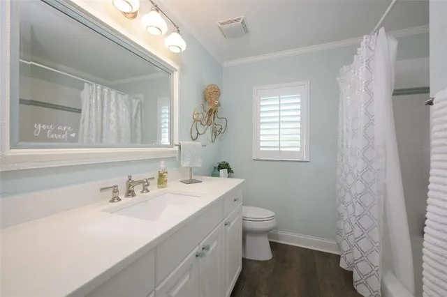 a bathroom with a sink a toilet and a window