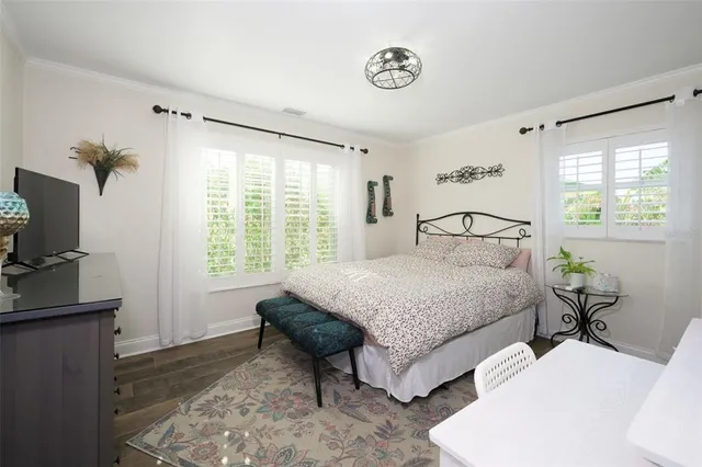 a bedroom with a bed and a table in it with window