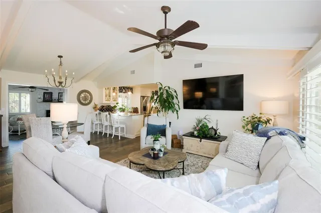 a living room with furniture a flat screen tv and a chandelier