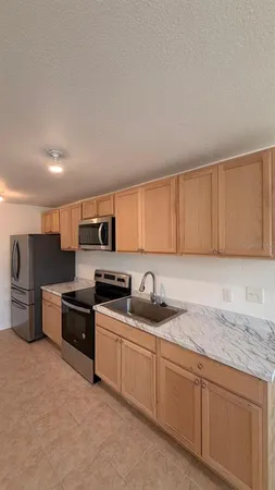 a kitchen with stainless steel appliances granite countertop a sink stove and cabinets