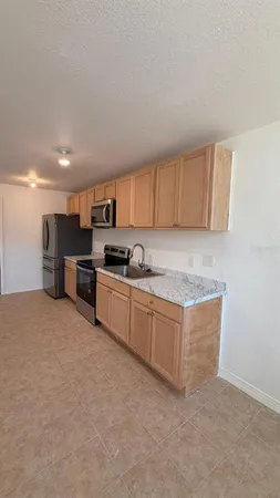 a kitchen with stainless steel appliances granite countertop a stove a sink and a refrigerator