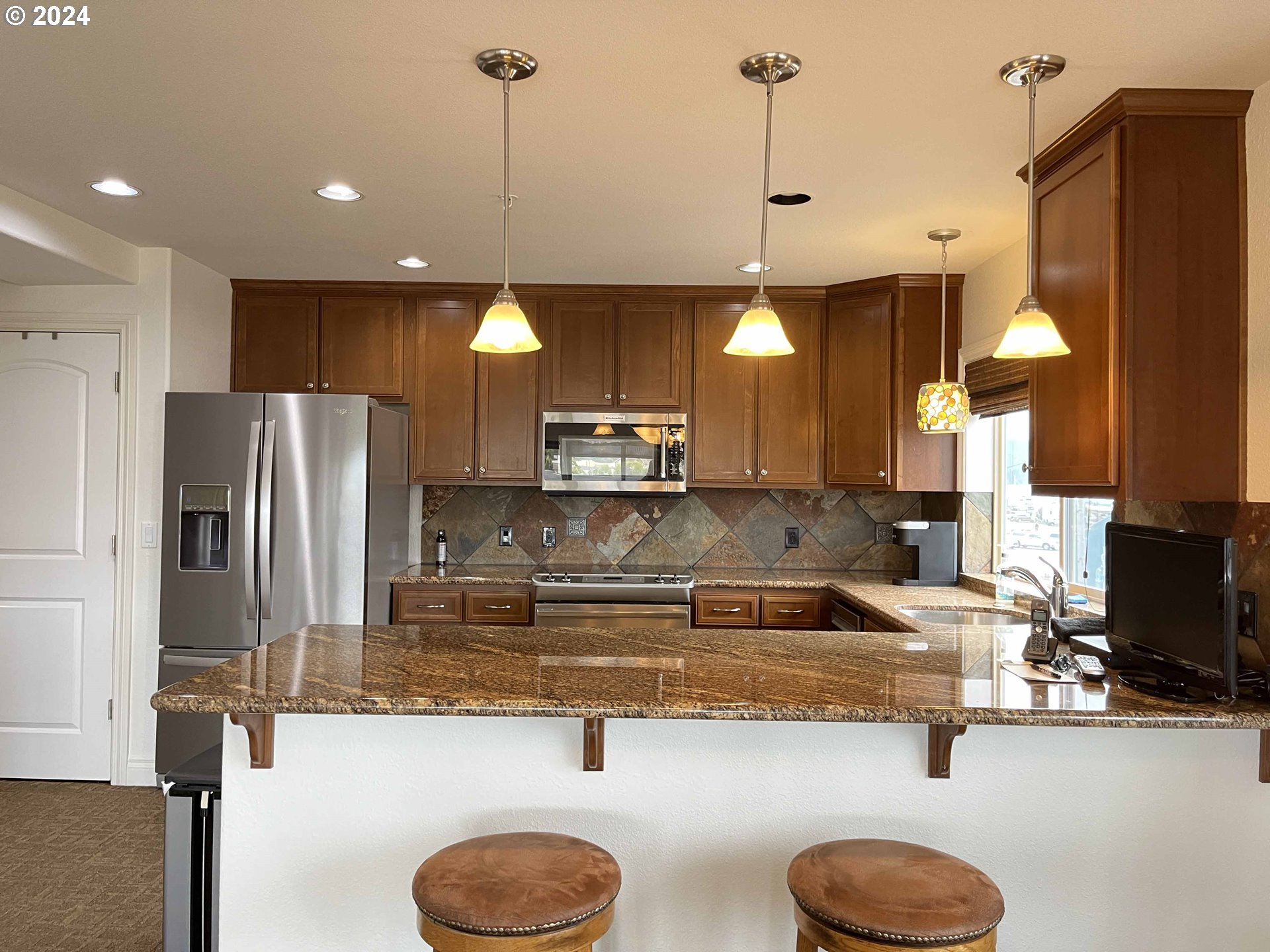 211 Harbor Street, Unit 31 Florence, OR 97439 - Photo 13 of 44 a kitchen with kitchen island a sink stainless steel appliances and cabinets