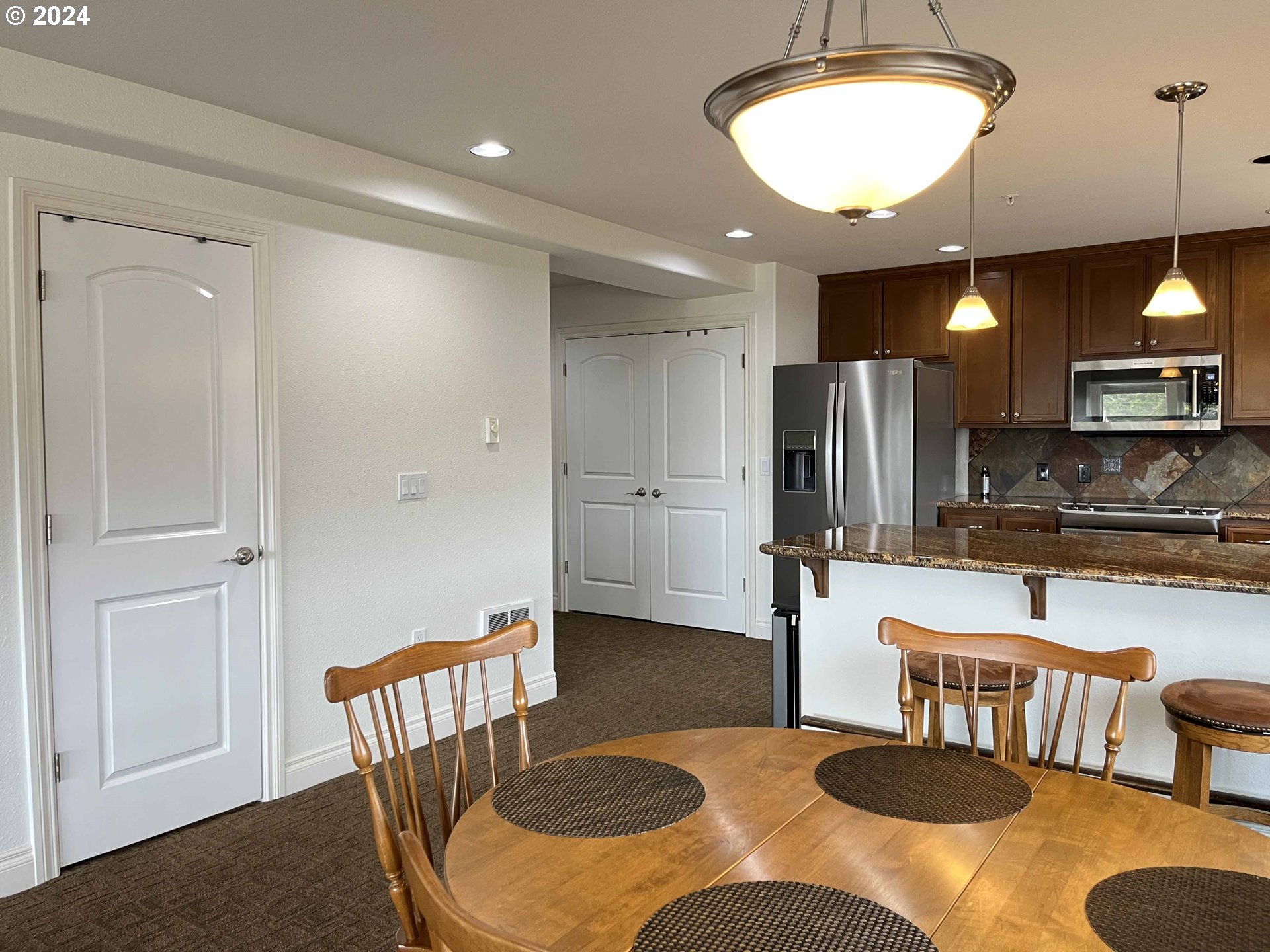 211 Harbor Street, Unit 31 Florence, OR 97439 - Photo 15 of 44 a kitchen with a table chairs and a refrigerator