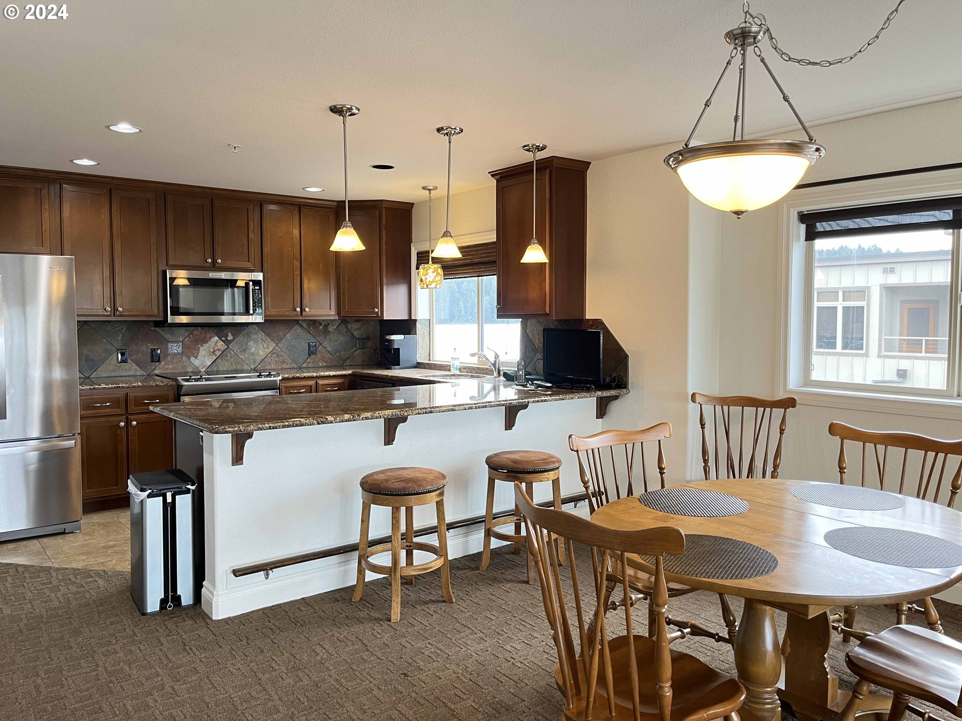 211 Harbor Street, Unit 31 Florence, OR 97439 - Photo 17 of 44 a kitchen with kitchen island granite countertop a table and chairs