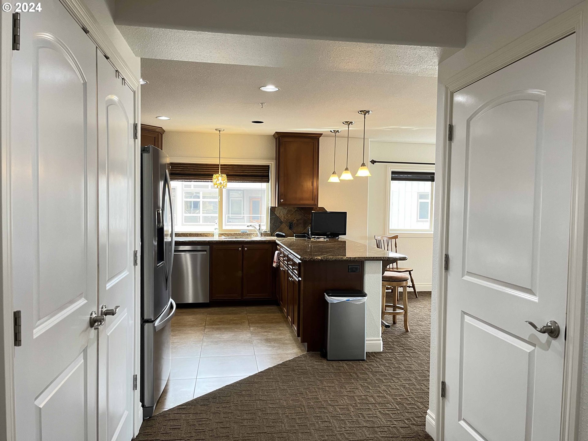 211 Harbor Street, Unit 31 Florence, OR 97439 - Photo 5 of 44 a kitchen with stainless steel appliances kitchen island granite countertop a refrigerator and a sink