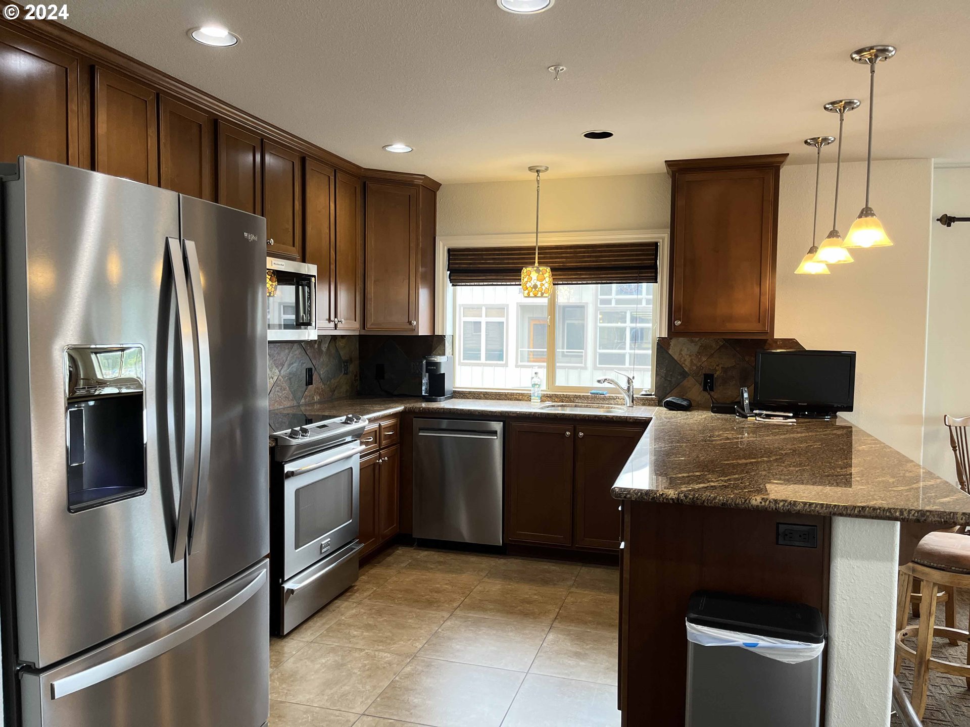 211 Harbor Street, Unit 31 Florence, OR 97439 - Photo 7 of 44 a kitchen with stainless steel appliances granite countertop a refrigerator a stove a sink and a microwave