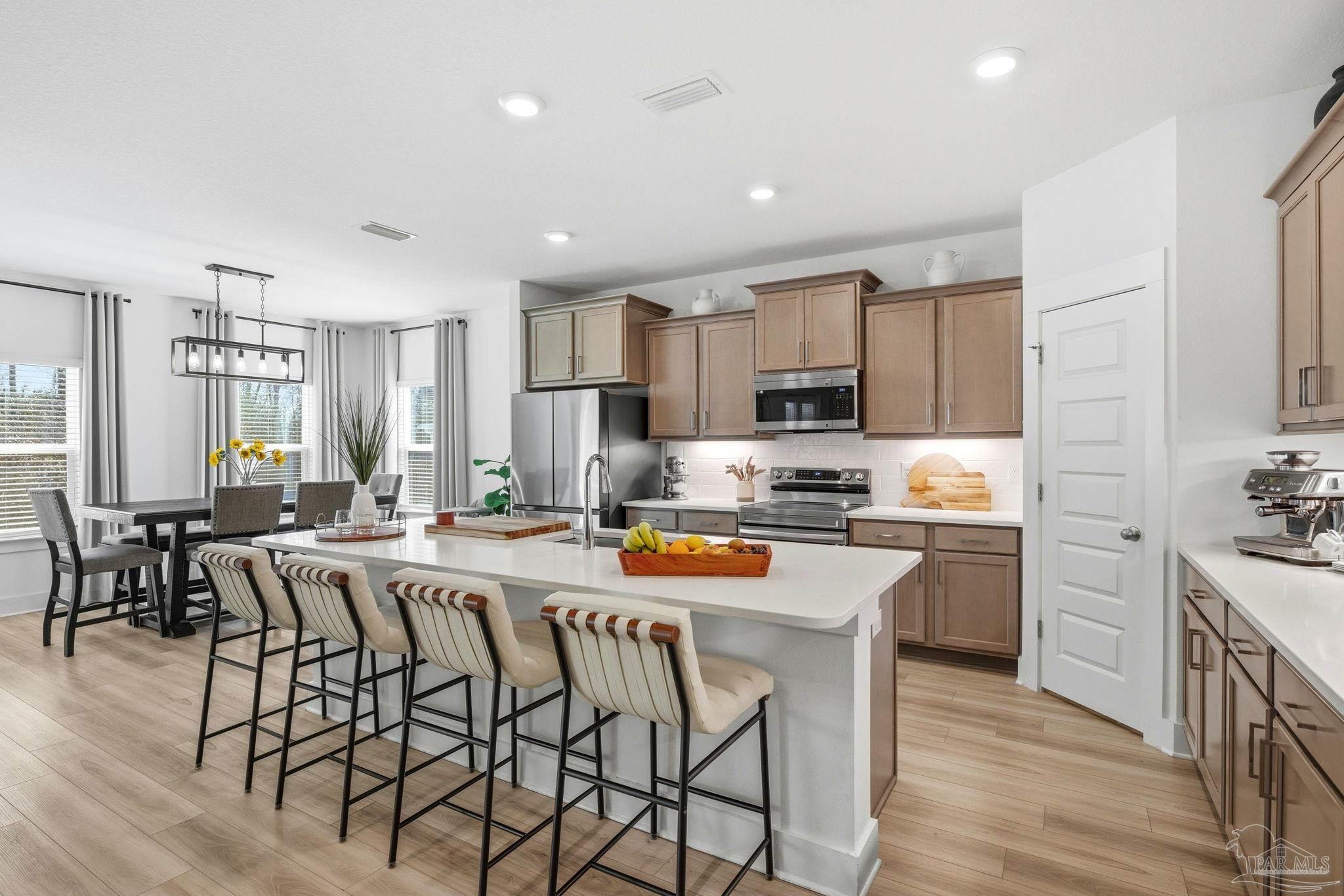 6228 Dry Crk Road Molino, FL 32577 - Photo 11 of 64 a kitchen with stainless steel appliances lots of white cabinets a table and chairs