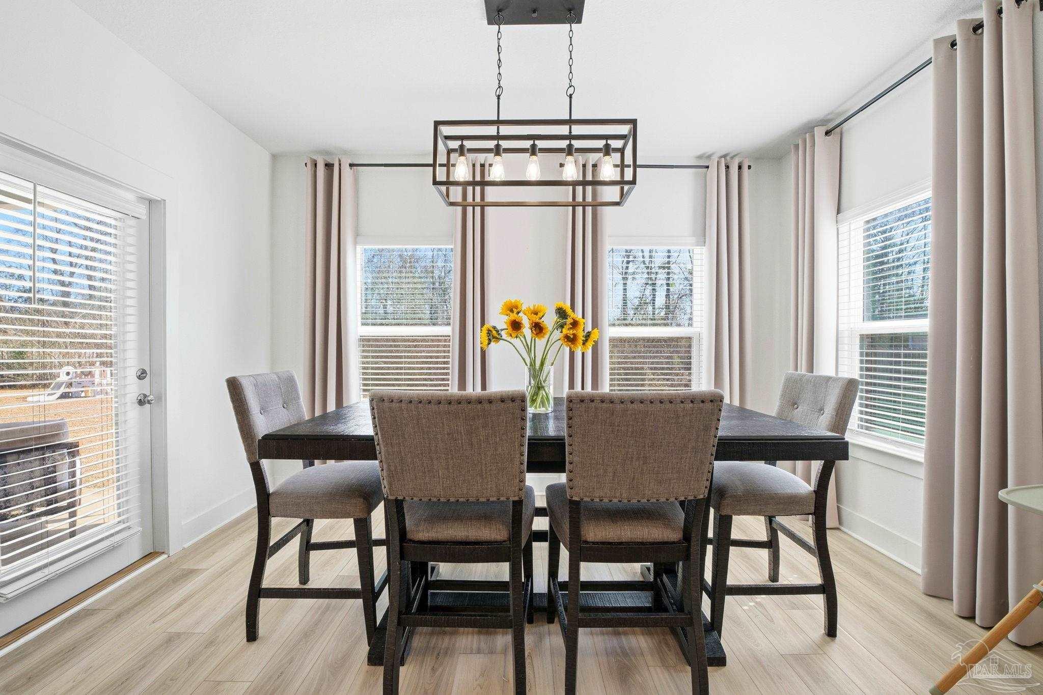 6228 Dry Crk Road Molino, FL 32577 - Photo 18 of 64 a dining room with furniture a chandelier and wooden floor