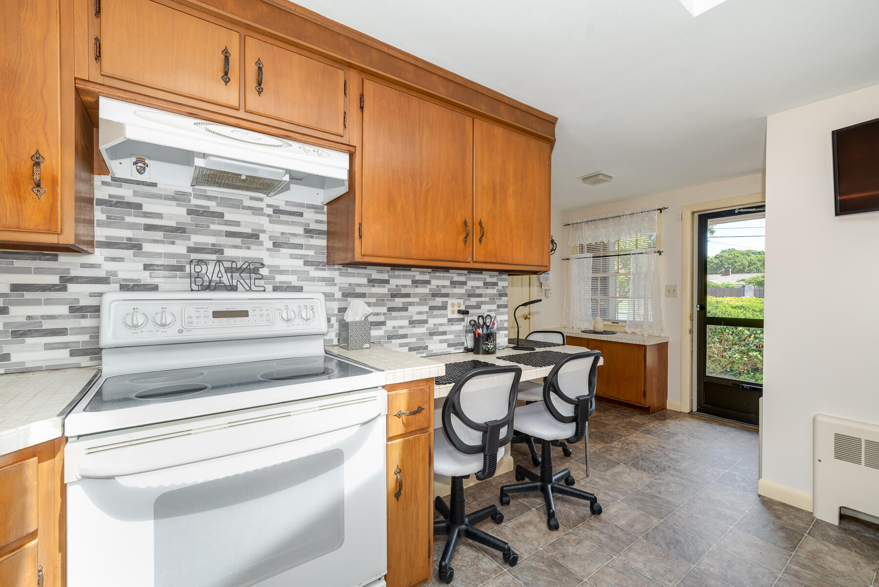 129 Bacon Road Hyannis, MA 02601 - Photo 11 of 43 a kitchen with a stove a chair and a refrigerator