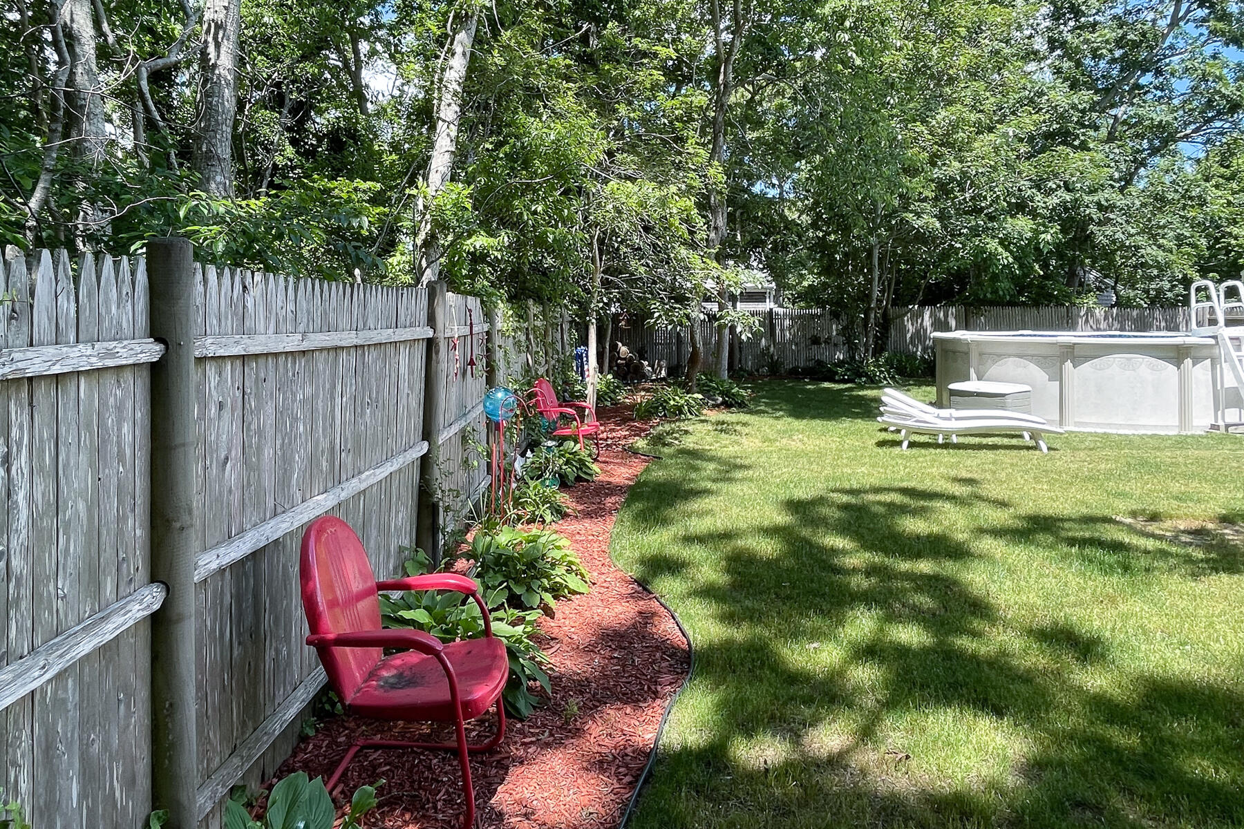 129 Bacon Road Hyannis, MA 02601 - Photo 36 of 43 a view of a backyard with wooden fence and a bench