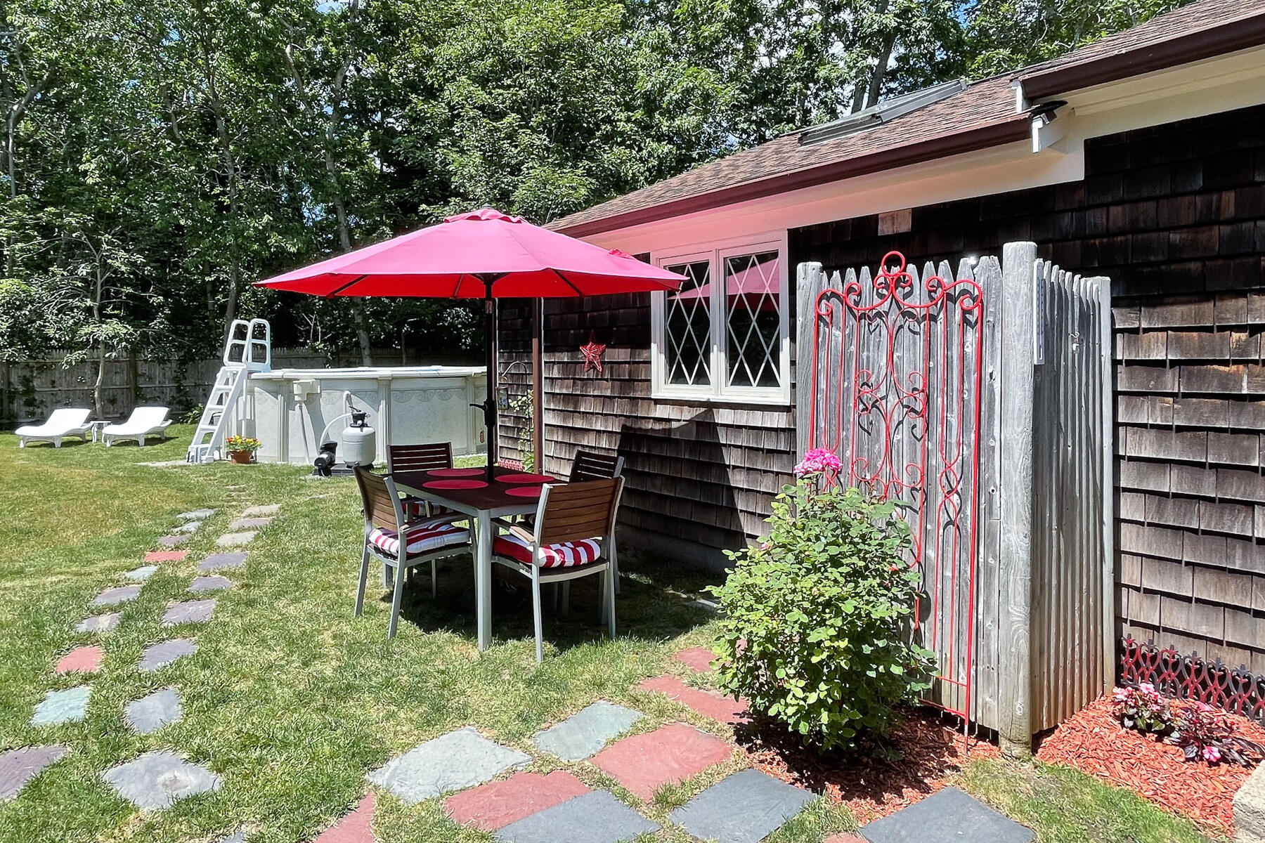 129 Bacon Road Hyannis, MA 02601 - Photo 38 of 43 a patio with a table and chairs under an umbrella