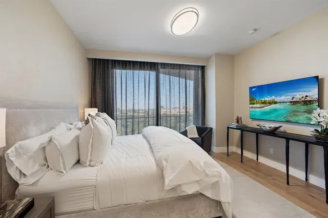 a bedroom with bed and large windows