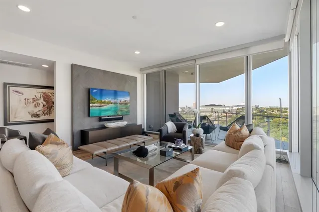 a living room with furniture large window and a flat screen tv