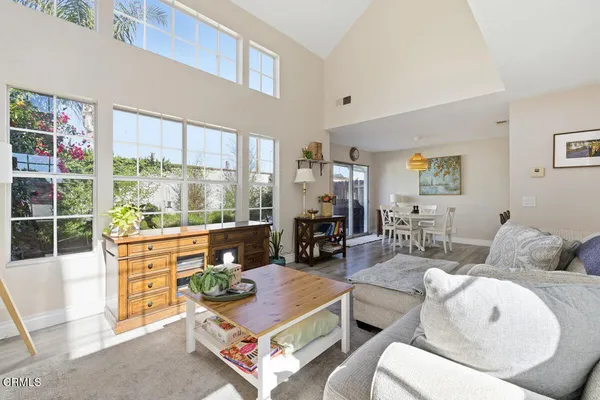 a living room with furniture a large window and dining table