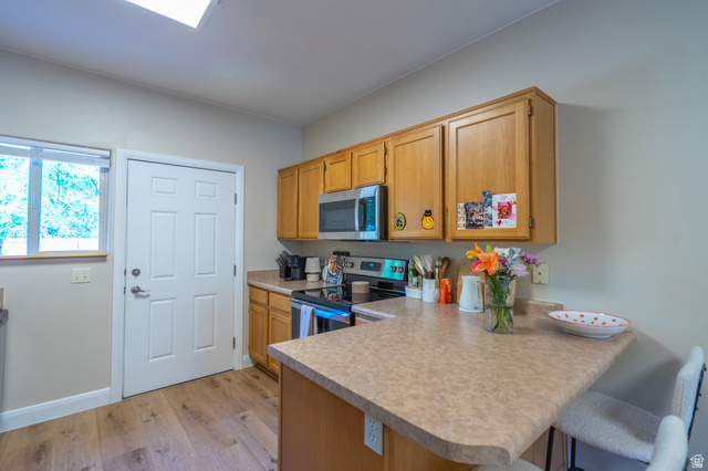 700 North Main Street, Unit F3 Washington, UT 84780 - Photo 8 of 34 Kitchen featuring wood-finish cabinetry, a stainless steel microwave, and a black and stainless steel range