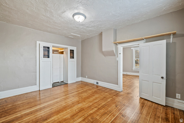 75 600 West Provo, UT 84601 - Photo 10 of 26 Hardwood flooring throughout, neutral painted walls, white trim, recessed entry with paneled doors, and a ceiling-mounted light fixture