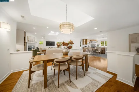 a kitchen with a stove a refrigerator a sink dishwasher with a dining table and chairs