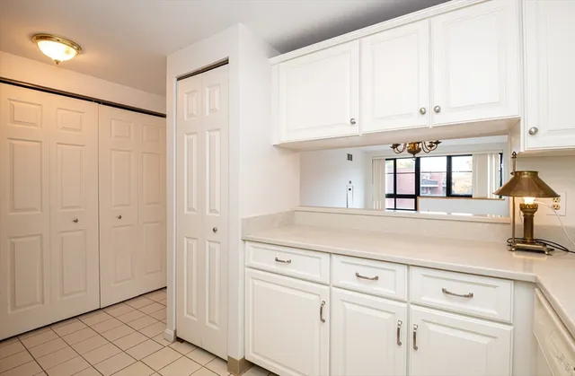 a kitchen with white cabinets and white appliances