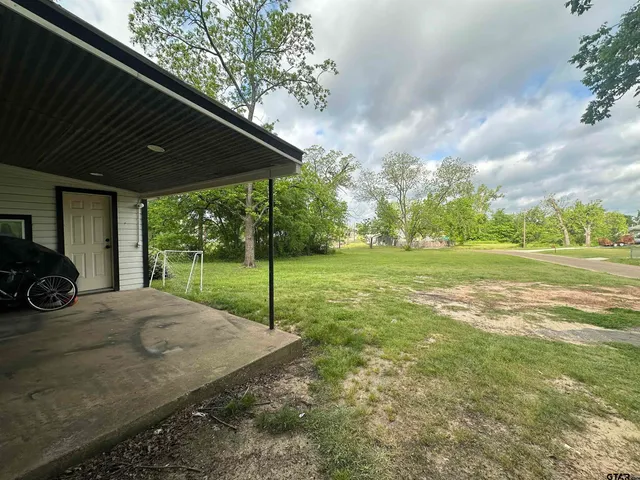 a view of a house with backyard and porch