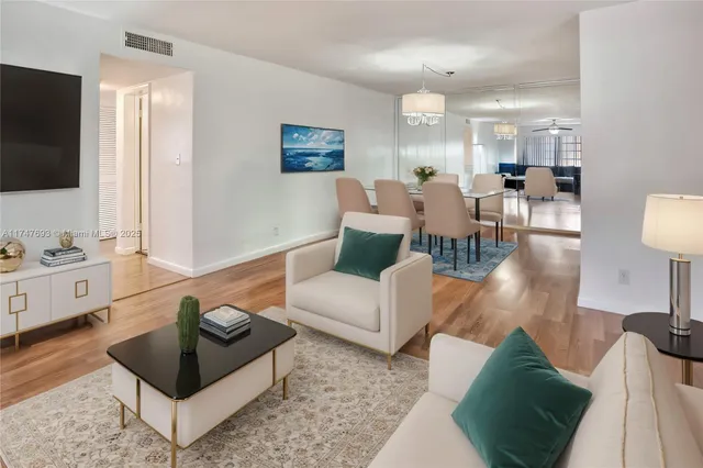 a living room with furniture a flat screen tv and a view of kitchen