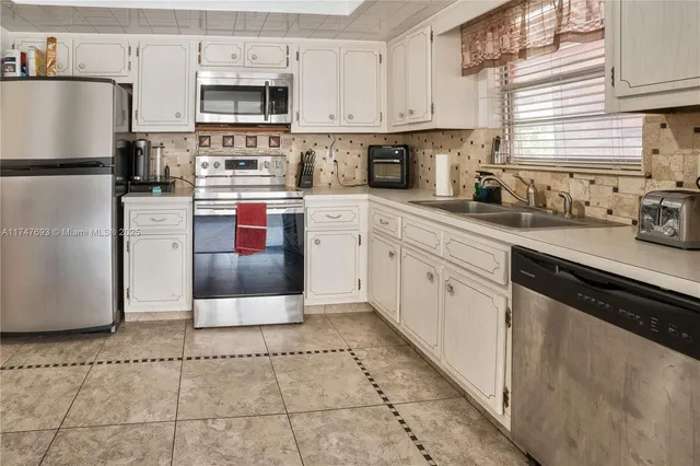 a kitchen with stainless steel appliances a refrigerator sink stove microwave and cabinets