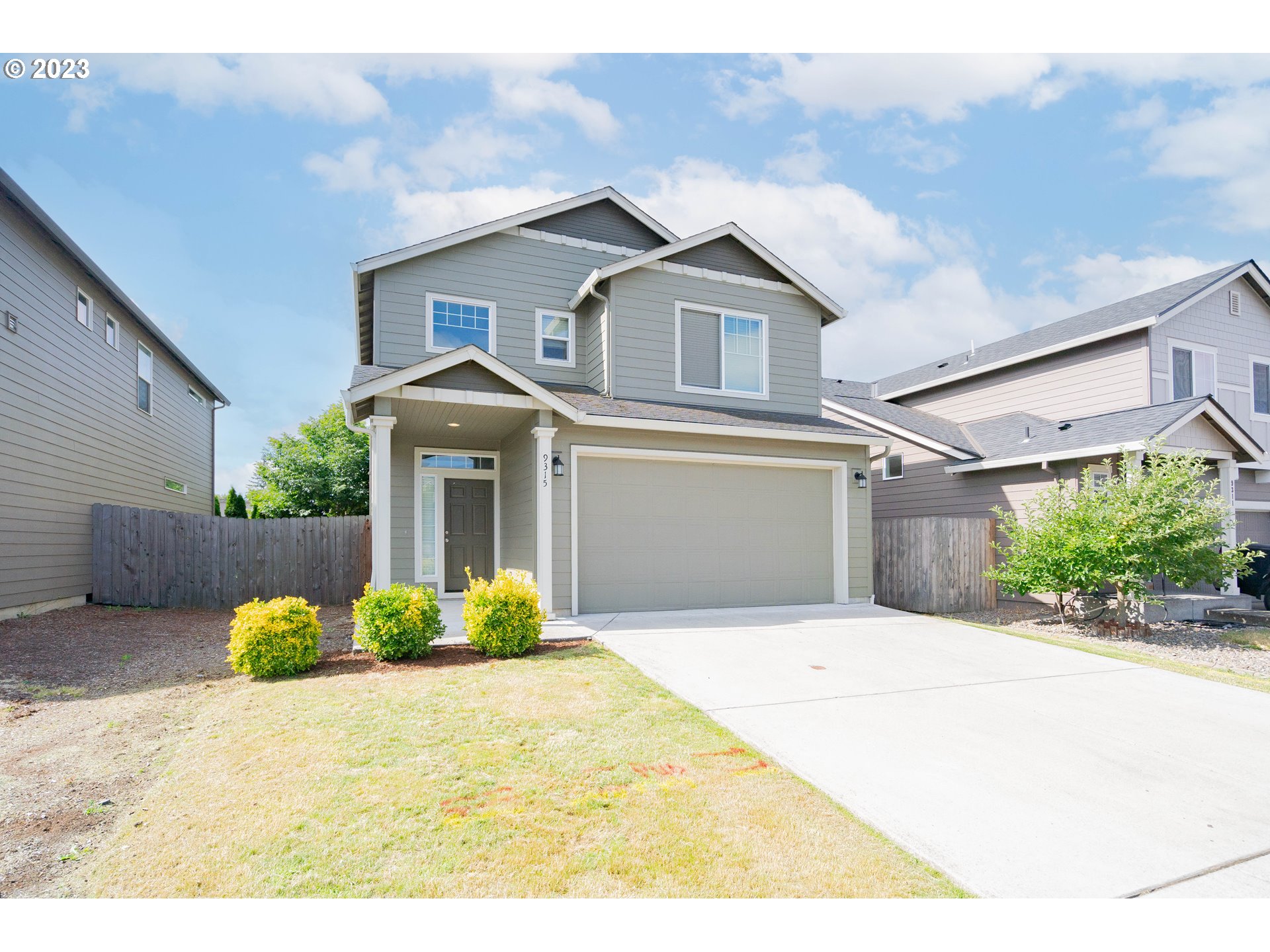 a front view of a house with a yard and a garage