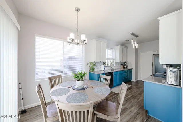 a kitchen with granite countertop kitchen island stainless steel appliances sink stove living room dining table and chairs