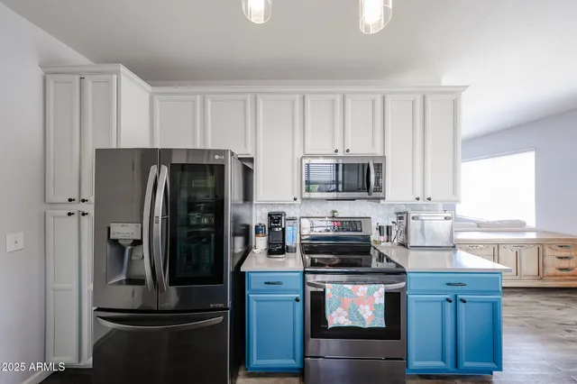 a kitchen with stainless steel appliances a sink a window and cabinets