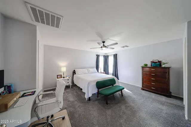 a bedroom with a bed mirror and a chair