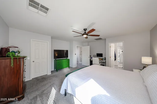 a spacious bedroom with a bed and a chandelier