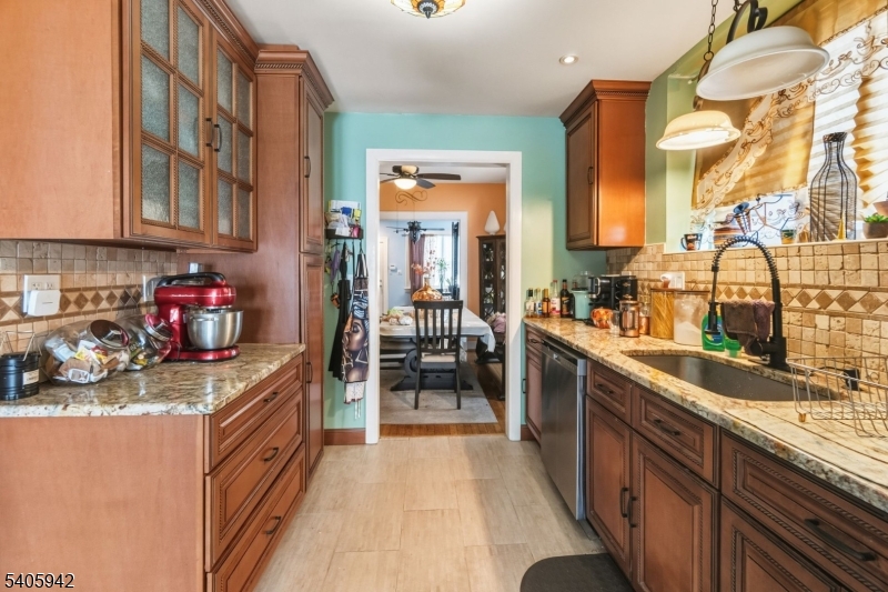 414 Martin Street Roselle, NJ 07203 - Photo 4 of 11 a kitchen with stainless steel appliances granite countertop sink stove and cabinets
