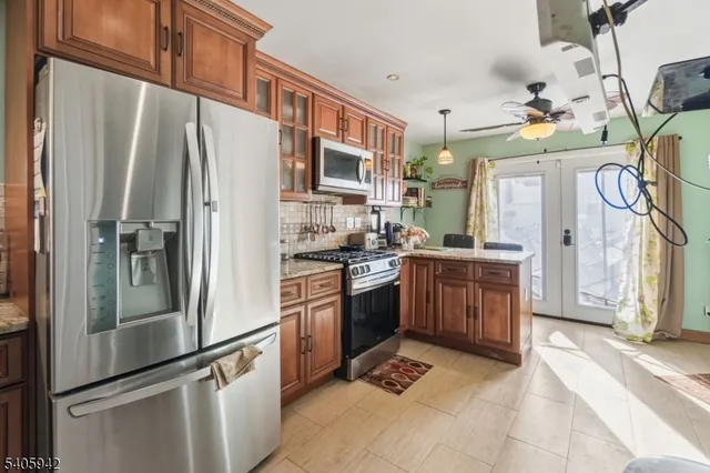 a kitchen with stainless steel appliances granite countertop a refrigerator a stove and a sink with cabinets