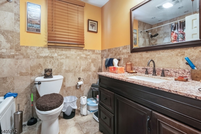 414 Martin Street Roselle, NJ 07203 - Photo 10 of 11 a bathroom with a granite countertop toilet sink and mirror