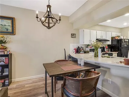 a kitchen with a dining table chairs and a refrigerator